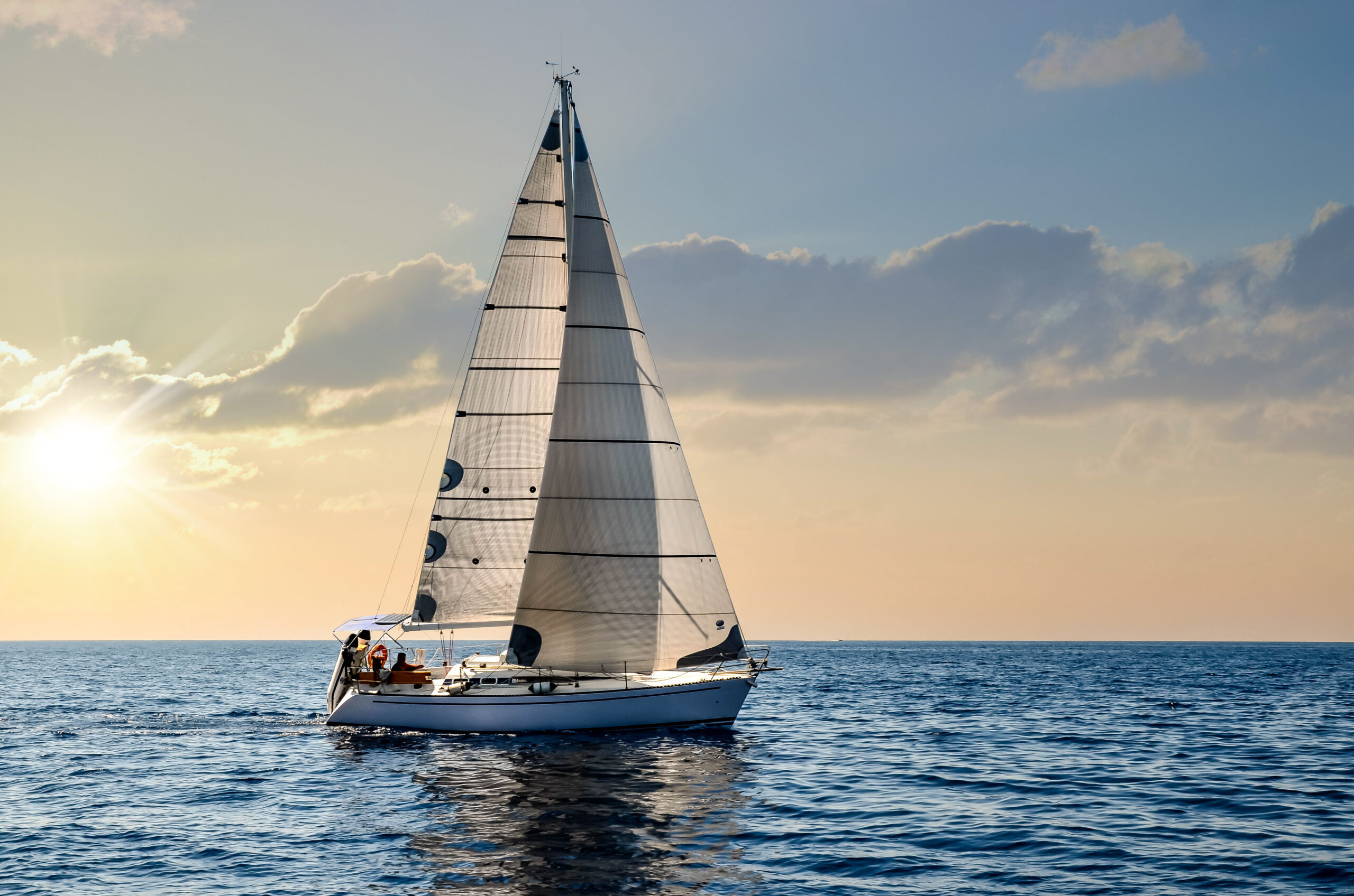 Yacht sailboat navigating Floridian waters at sunset.